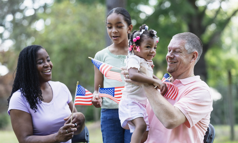 Multiracial family with American flags on US holiday