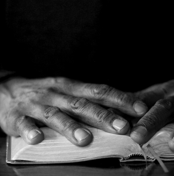 praying to god with hands together with black gray background with people stock image