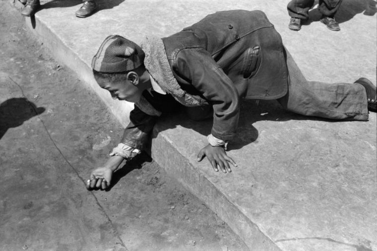 Young Boy playing Marbles, South Side, Chicago, Illinois, USA, Russell Lee, U.S. Office of War Information/U.S. Farm Security Administration, April 1941