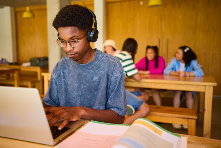 Focused teen studying on laptop - Legal Defense Fund Sues Trump Admin Over DEI Policy