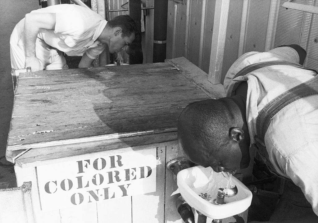 history of segregated facilities trump era -  Men Drinking from Segregated Water Fountains, segregation, Black people, white people 