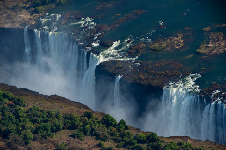 Aerial View of Majestic Victoria Falls Cascading Into the Zambezi Gorge Surrounded by Lush Forest and Rugged Terrain. Africa, Travel, Safety