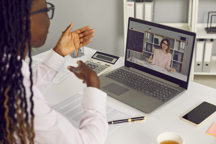 Woman business accountant having discussion with teacher via video call on laptop