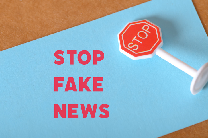 Alert Poster Concept: STOP FAKE NEWS in Red Letters with Stop Sign for Misinformation Awareness Campaign