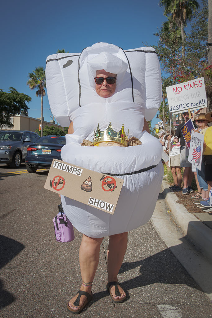 Participant wearing a costume seen holding a sign at the...