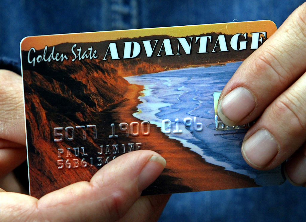 Janine Paul showing her food stamps debit card that replaces the packet of coupons and may contribut