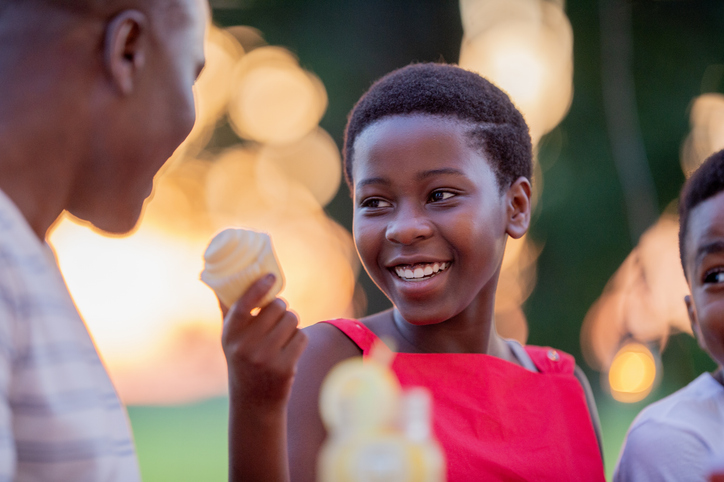 Joyful Black Family Outdoor Summer BBQ Moment With Ice Cream and Laughter
