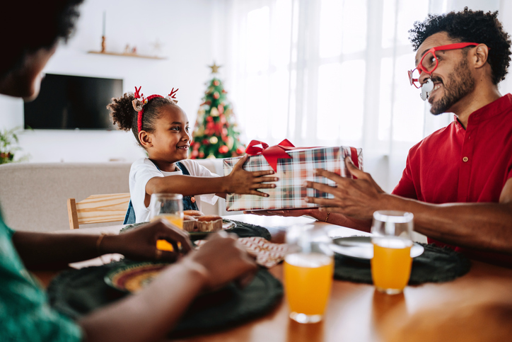 Father Giving Christmas Gift to Daughter at the Dining Table