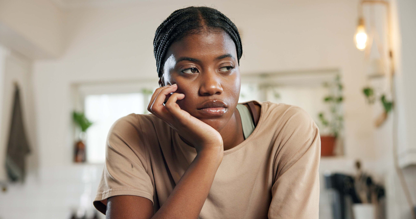 Thinking, sad and woman with depression in home for unemployment, job stress or disappointed. Bored, hopeless and black person with overthinking for mental health, jobless and overwhelmed by failure
