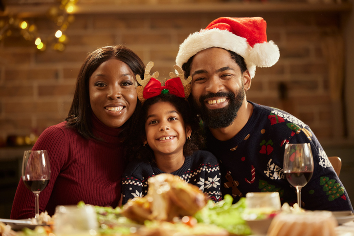 Portrait of happy black family on New Year's in dining room.