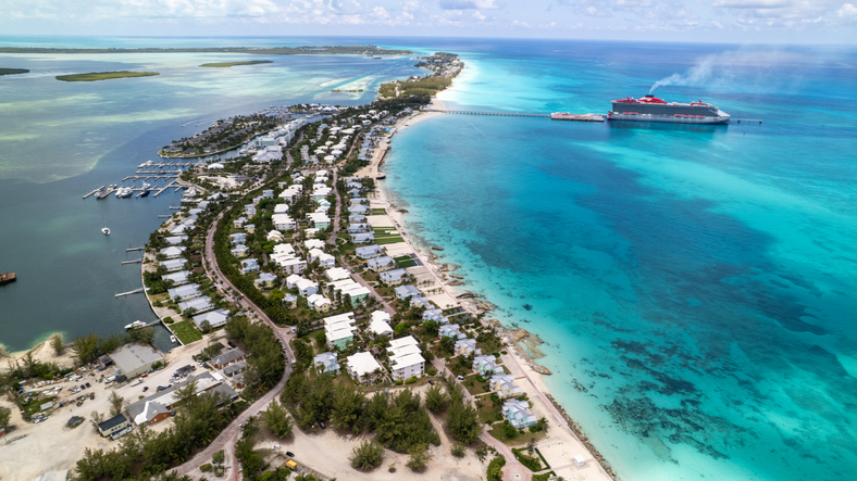 High angle aerial view of a tropical island with a cruise ship docked at a pier, surrounded by turquoise ocean and white sand beaches,Bahamas