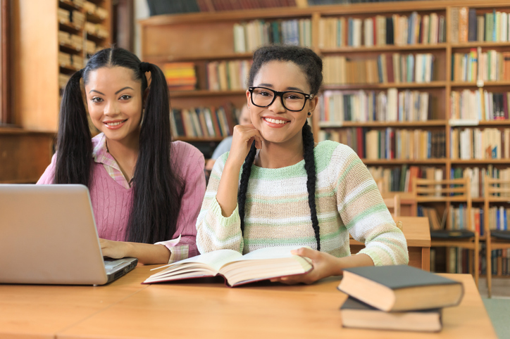 Diverse students reading books in university library