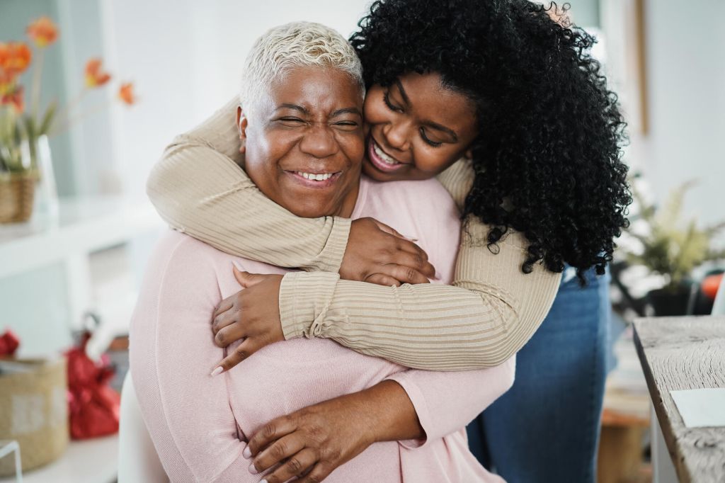 Black daughter hugging her mom