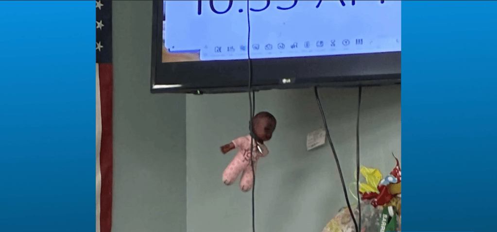 Doll hanging from television
