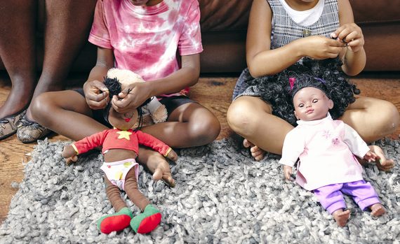 Girls sitting on floor and playing with dolls