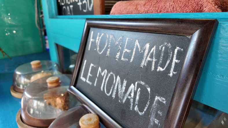 Enjoying fresh homemade lemonade at a colorful stand