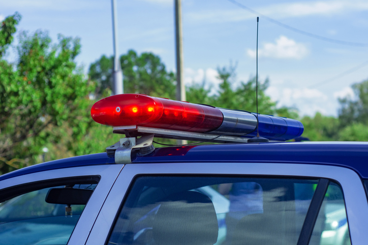 Close-up of police car roof with red and blue emergency light bar turned on. Law enforcement concept, public safety, emergency response, patrol vehicle, alert signal and urban security background.