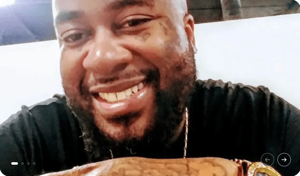 A smiling man with a beard wearing a black jacket