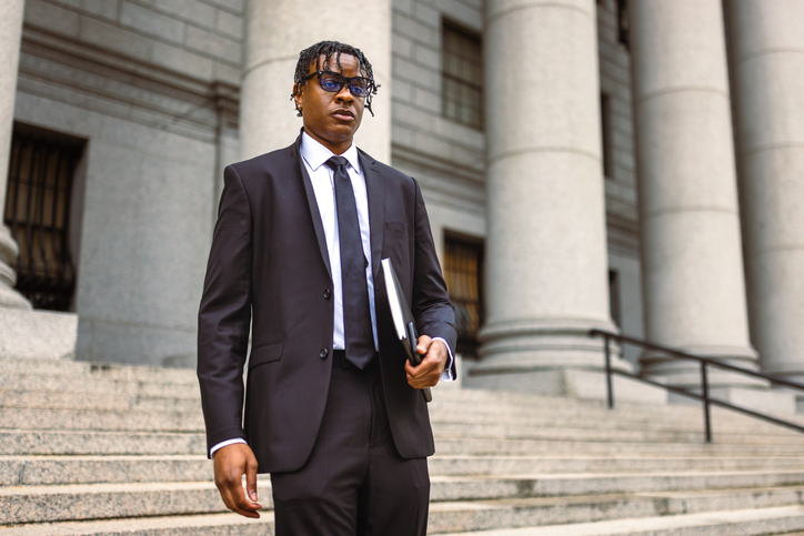 Professionally dressed man walking down courthouse steps