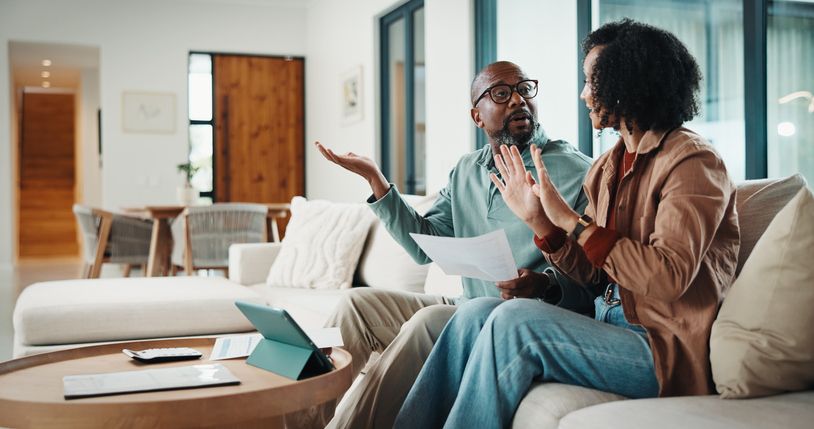 Black couple having a conversation on the couch
